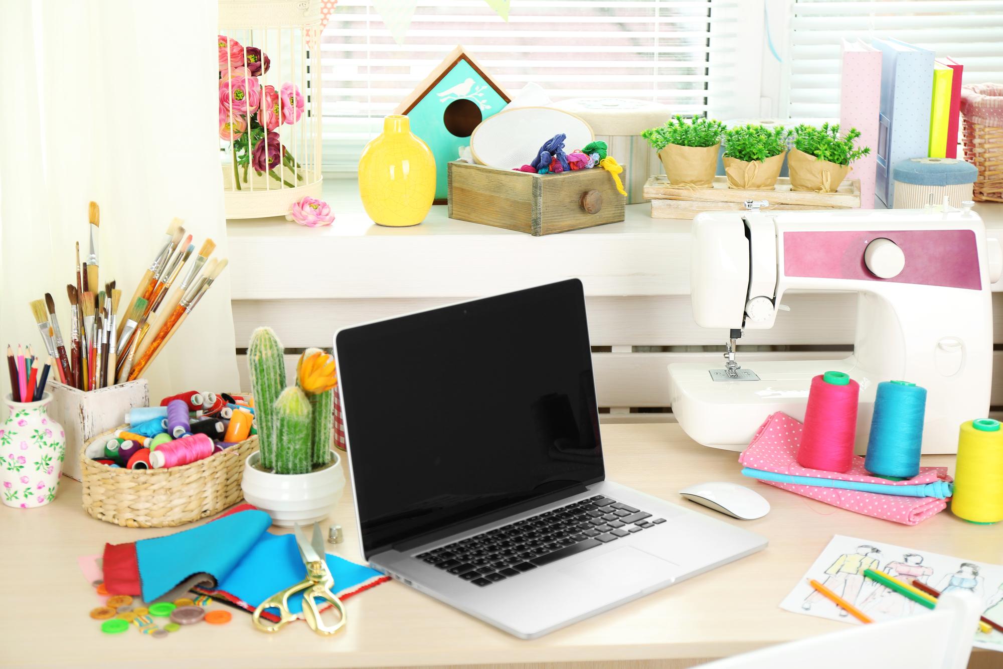 Tavolo con kit di ricamo e laptop